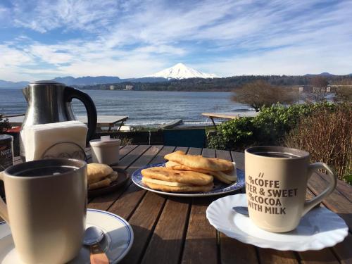 比亚里卡Volcano & Lake Family Hostel的一张桌子,上面放着两杯咖啡和盘子