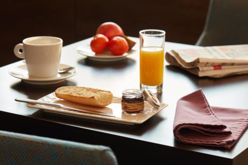 勒芒Ashley Hôtel Le Mans Centre Gare的一张桌子,上面放着一盘食物和一杯橙汁