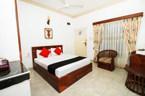 亭可马里JKAB Park Hotel的一间卧室配有一张床、一张桌子和一把椅子