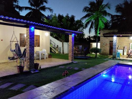 瓜吉鲁casa na praia de guajiru的夜间在房子前面的游泳池