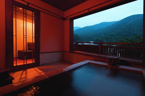 箱根Hakone Onsen Ryokan Yaeikan的客房设有游泳池和大窗户。
