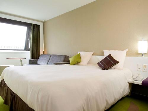 梅里尼亚克宜必思尚品波尔多机场酒店的一张大白色的床,位于酒店客房内