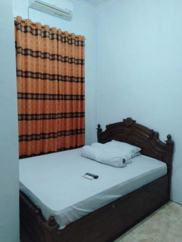 BaubauWisma Kahyangan的木架床和窗帘