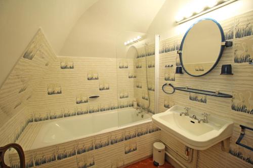 Saint-Priest-TaurionDomaine de Bort的带浴缸、水槽和镜子的浴室