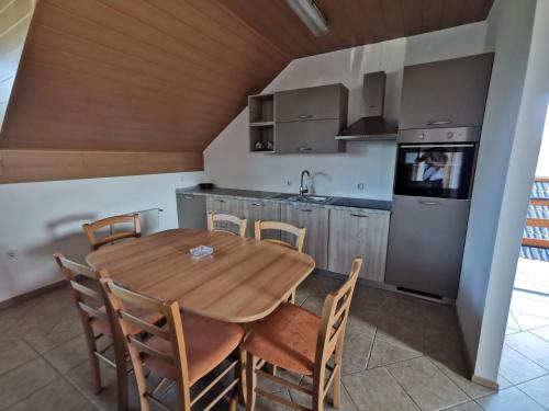 Spodnje HočePohorje的厨房以及带木桌和椅子的用餐室。