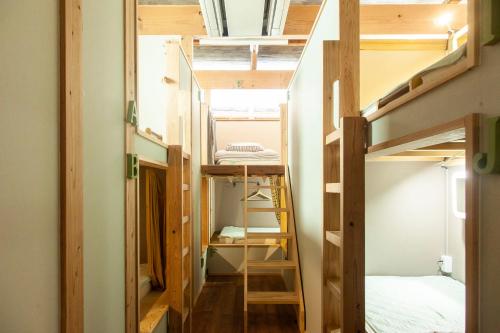 福冈Fukuoka Guesthouse HIVE的一个小房子,设有楼梯和一张双层床