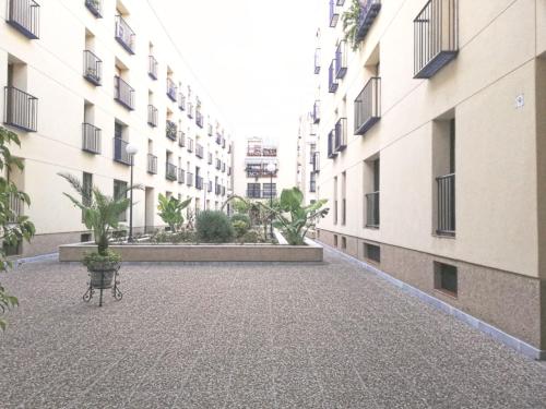 塞维利亚Apartamento zona Palacio de las Dueñas y las Setas的一座空的庭院,楼前设有长凳