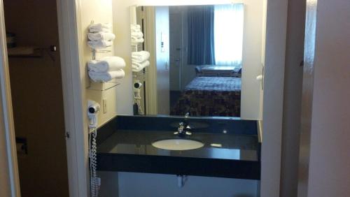 普雷斯科特遗产连锁汽车旅馆的一间带水槽和镜子的浴室以及一张床