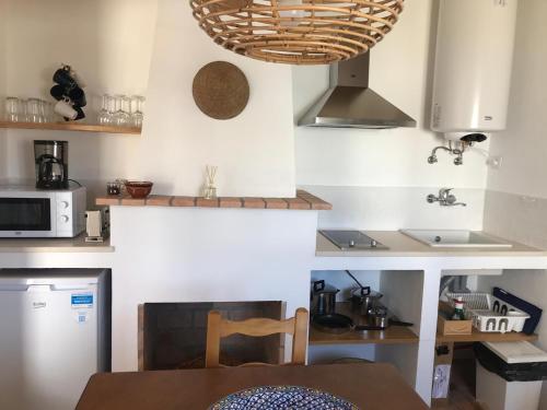 莫托拉Casas de Mértola - N. Sª das Neves的一间带桌子和微波炉的小厨房