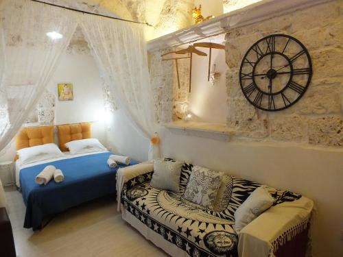 切列梅萨皮卡Casa Cuore di Pietra "STONEHEART HOME"的卧室配有一张床,墙上挂着一个钟