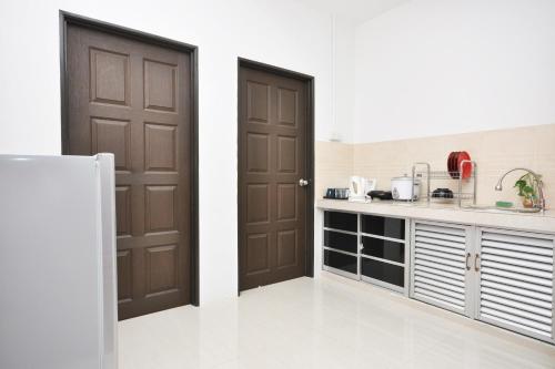 瓜拉丁加奴Ada Hotel & Apartment的厨房设有两扇棕色的门和柜台