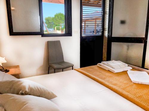 切萨雷奥港Il mondo dei sogni的一间卧室配有一张床、一把椅子和窗户。