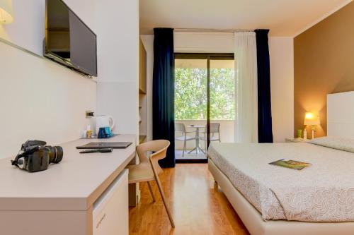 西尔米奥奈瑞尔酒店的一间卧室配有一张床和一张带笔记本电脑的书桌