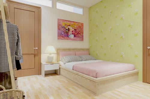 岘港哈雷民宿的卧室配有一张床,墙上挂有绘画作品