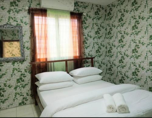 蕉赖2 BR Medina Dollar Landed Homestay Cheras MRT Link的卧室内的两张床,配有绿色和白色的壁纸