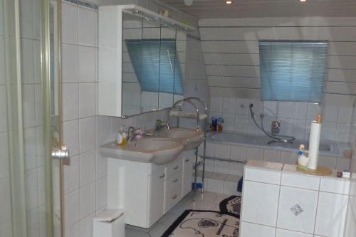 Mengersgereuth-HämmernFerienwohnung Schelhorn的浴室配有盥洗盆、镜子和浴缸