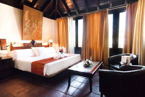 格拉纳达卡萨帕拉西奥皮拉尔·德尔·托罗酒店的一间卧室配有一张床、一张桌子和一张桌子。