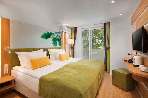 普里莫尔斯科Hotel Forest Beach的酒店客房设有一张大床和一台电视。