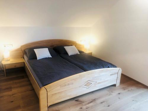 KrakaudorfFeielhof的一间卧室配有一张带两个枕头的大木床