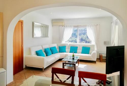 莫莱拉Villa Guapa With Gym Aircon Wifi Moraira的客厅配有白色沙发和蓝色枕头。