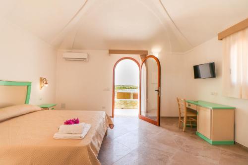 兰佩杜萨Casa Zita Lampedusa的一间卧室配有一张床、一张书桌和一台电视