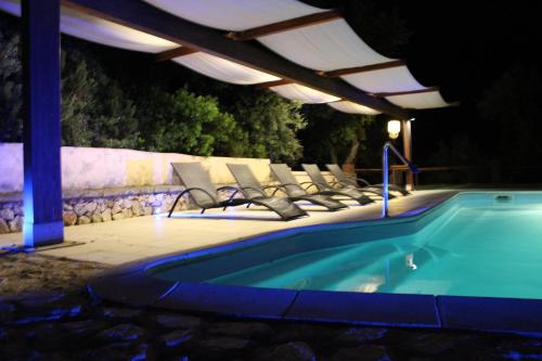 阿尔布斯La Quercia的一群椅子在晚上坐在游泳池旁边