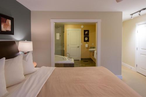 Madeira Park画舫码头Spa度假酒店的一间卧室配有一张床,浴室设有浴缸