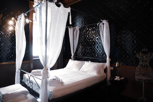 贝加莫Ilsanleonardo的卧室配有带白色窗帘的天蓬床