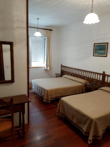 里瓦德奥HOSTAL RESIDENCIA PRESIDENTE的酒店客房设有两张床和窗户。
