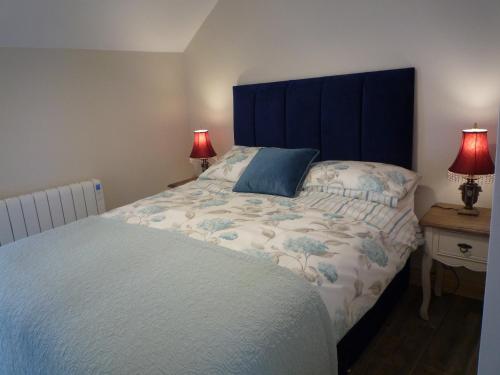塔拉莫尔Kitty's的一间卧室配有一张带蓝色床头板的床和两盏灯。