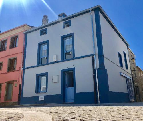 利洛Apartamentos Turísticos Casa Dina的街上的蓝色和白色建筑