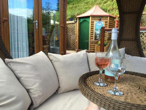 格伦德文Ramintoul Lodge的桌子上放有一瓶葡萄酒和两杯酒