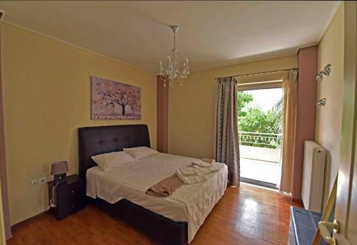 哈尔基斯Sea View Apartment的一间卧室配有一张带吊灯和窗户的床。