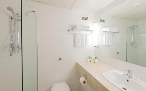 奥克兰国敦酒店的白色的浴室设有水槽和淋浴。
