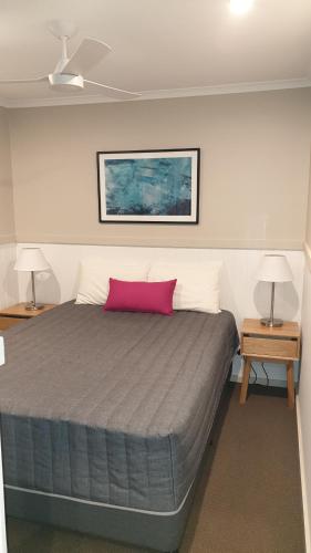 维克多港NRMA维克多港海滨度假公园的一间卧室配有一张带粉红色枕头的大床