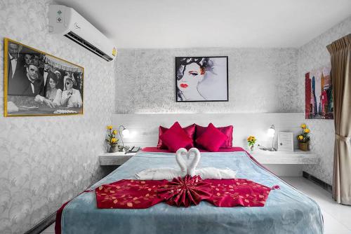 芭东海滩The Shades Hotel 50 meter Beach Front的一间卧室配有红色枕头的床