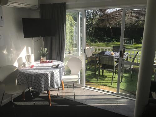 基督城桑迪菲特旅馆的一间带桌椅的用餐室和一个庭院