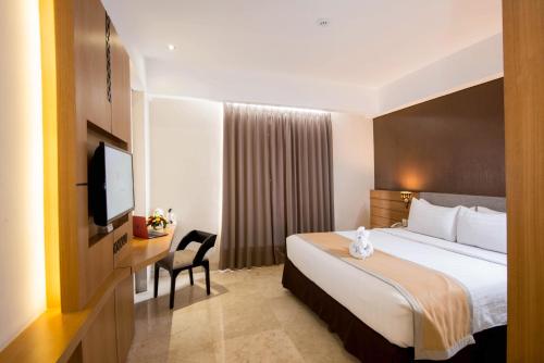 日惹里恩地平线酒店的配有一张床和一台平面电视的酒店客房