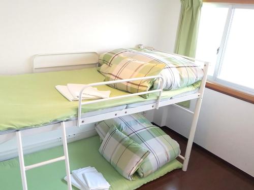 北九州小仓福冈小亚洲旅舍的配有双层床的小客房内的双层床