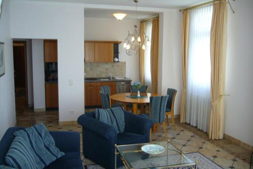 宾茨Meerblick-Appartement Villa Gudrun的一间带桌椅的客厅和一间厨房