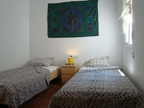 厄尔·波索·德·洛斯·弗莱尔Nuestra casita en CABO DE GATA的一间设有两张床的客房,墙上有地毯