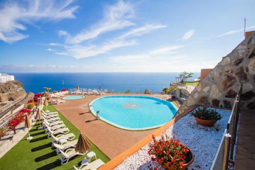 波多黎各阿马多雷斯宁静酒店的享有带椅子的游泳池和大海的景色