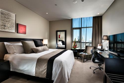 珀斯珀斯辉盛阁国际公寓的酒店客房配有一张床、一张书桌和一台电视。