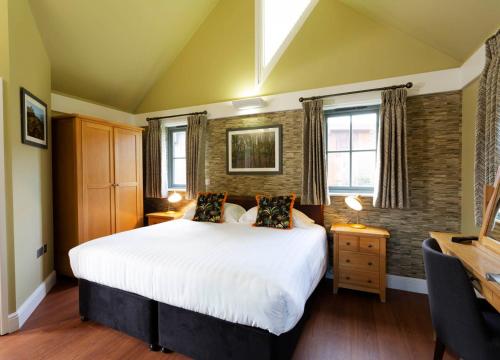 圣布雷拉德傲梅斯度假酒店的卧室设有一张白色大床和两个窗户。