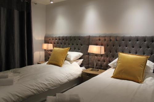 柯克沃尔Apt 1, Frasers Close, Kirkwall的一间卧室配有两张带黄色枕头的床