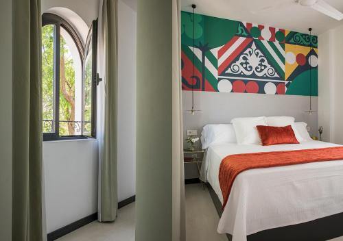 塞维利亚Feria Pool & Luxury的卧室配有一张床,墙上挂有绘画作品