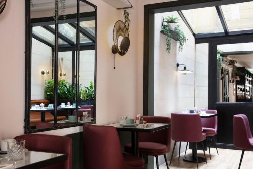 巴黎巴斯提尔斯佩利亚酒店的餐厅设有桌椅和窗户。