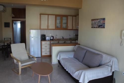 奥弗里安Paralia Ofriniou GR sunrise apartments 3的带沙发和桌子的客厅以及厨房。