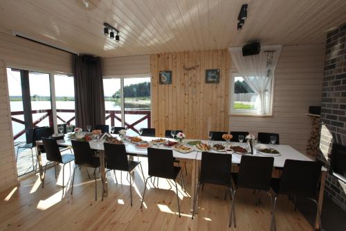 JaunmārupeKarpu dīķis-Kempings Viesītes的大型用餐室配有长桌和椅子