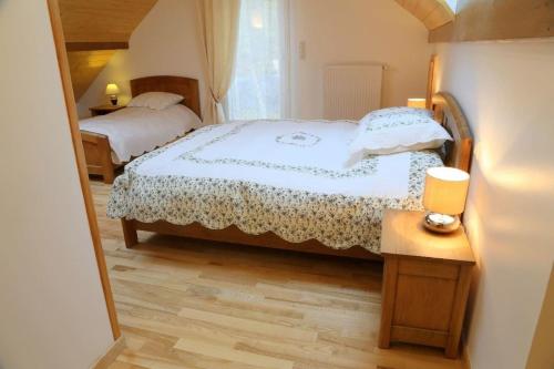 EssertGîte des Prés de la Douce的一间卧室配有两张床和一张带台灯的桌子